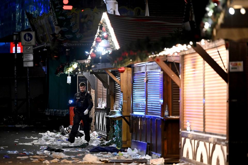 A police officer after the Christmas market was evacuated (Heiko Rebsch/dpa via AP)