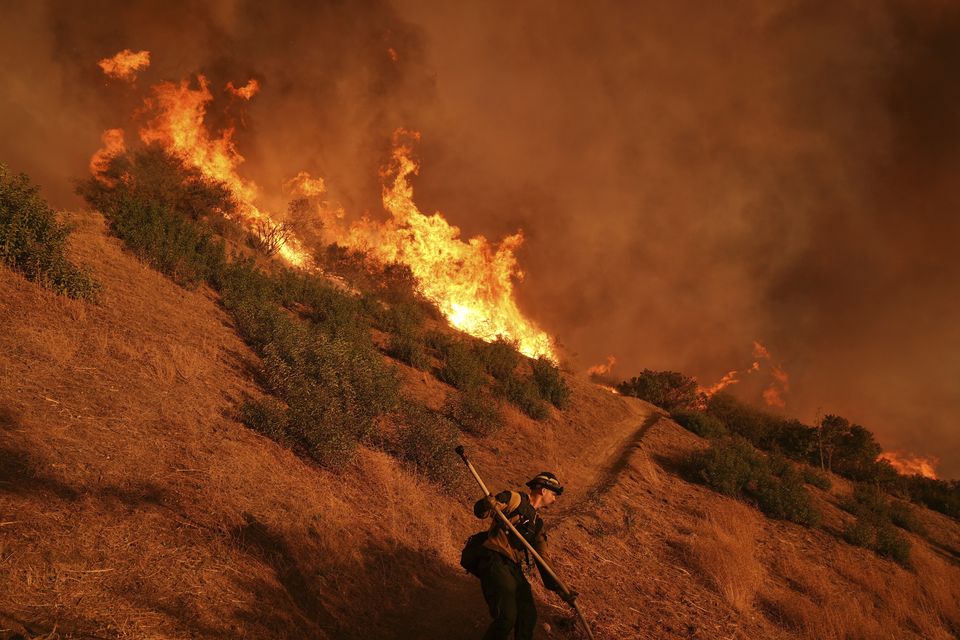 A firefighter battles the Palisades Fire in Mandeville Canyon (Jae C Hong/AP)