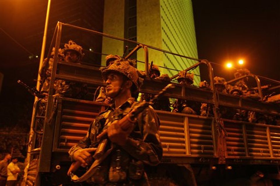 Indian army soldiers take positions near the Oberoi hotel in Mumbai, India, Thursday, Nov. 27, 2008. Black-clad Indian commandoes raided two luxury hotels to try to free hostages Thursday, and explosions and gunshots shook India's financial capital a day after suspected Muslim militants killed people. Backdrop is of the Air India building. (AP Photo/Gurinder Osan)