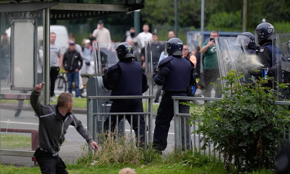 A protester throws an object at officers as they deploy pepper spray (Niall Carson/PA)