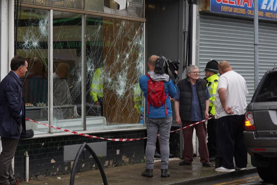 Police officers outside a damaged butchers shop on Murray Street in Hartlepool following an evening of unrest (Owen Humphreys/PA)