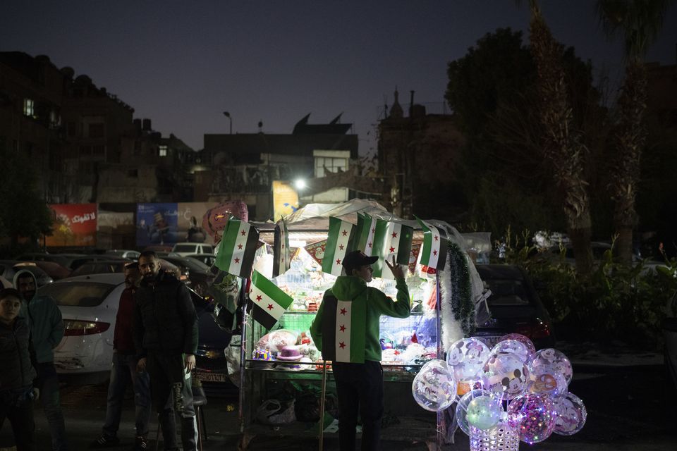 A street vendor flashes a victory sign in the Bab Touma neighborhood in the Old City of Damascus (Leo Correa/AP)