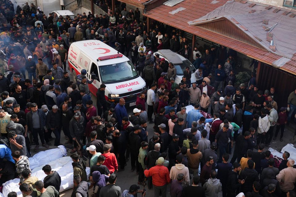 Mourners gather around the bodies of Palestinians who were killed in an Israeli army airstrikes as they are brought to Al-Ahli Hospital in Gaza City (Abdel Kareem Hana/AP)