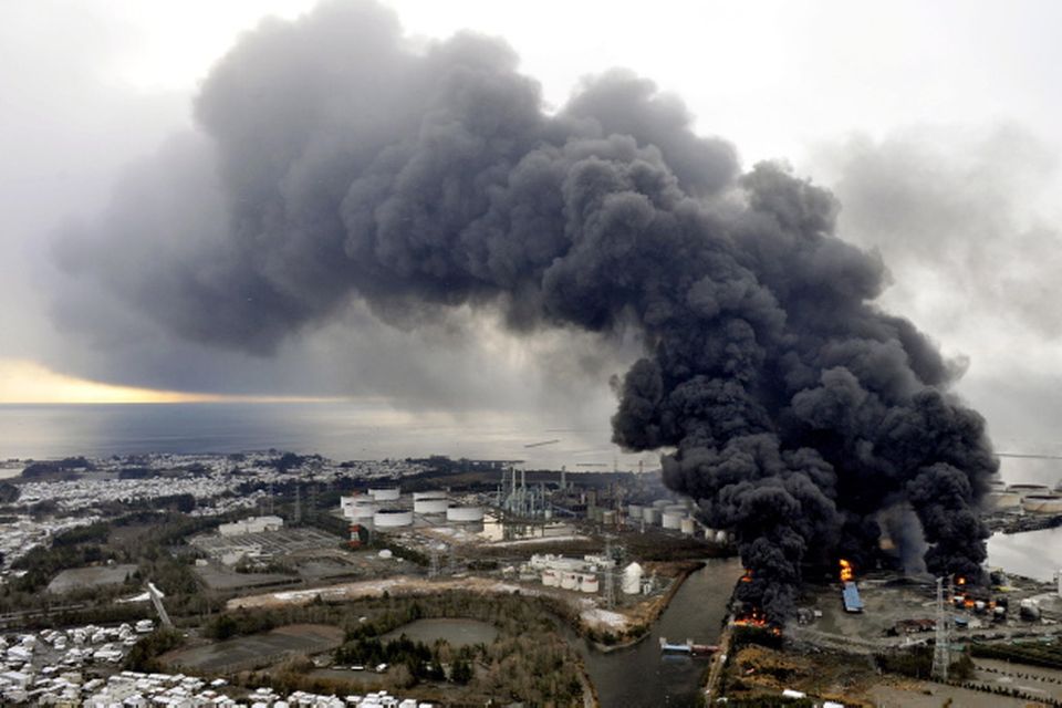 Black smoke rises from burning buildings in a factory zone in Sendai, Miyagi Prefecture, Saturday morning, March 12, 2011 after Japan's biggest recorded earthquake slammed into its eastern coast Friday