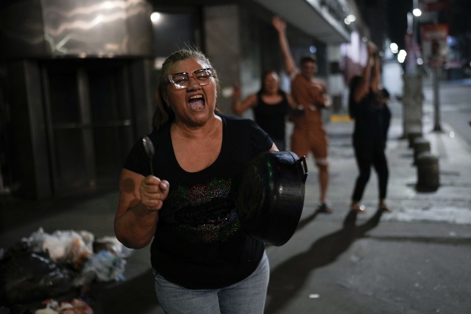 Supporters of opposition candidate Edmundo Gonzalez bang pots after the polls closed for the presidential election in Caracas (Matias Delacroix/AP)