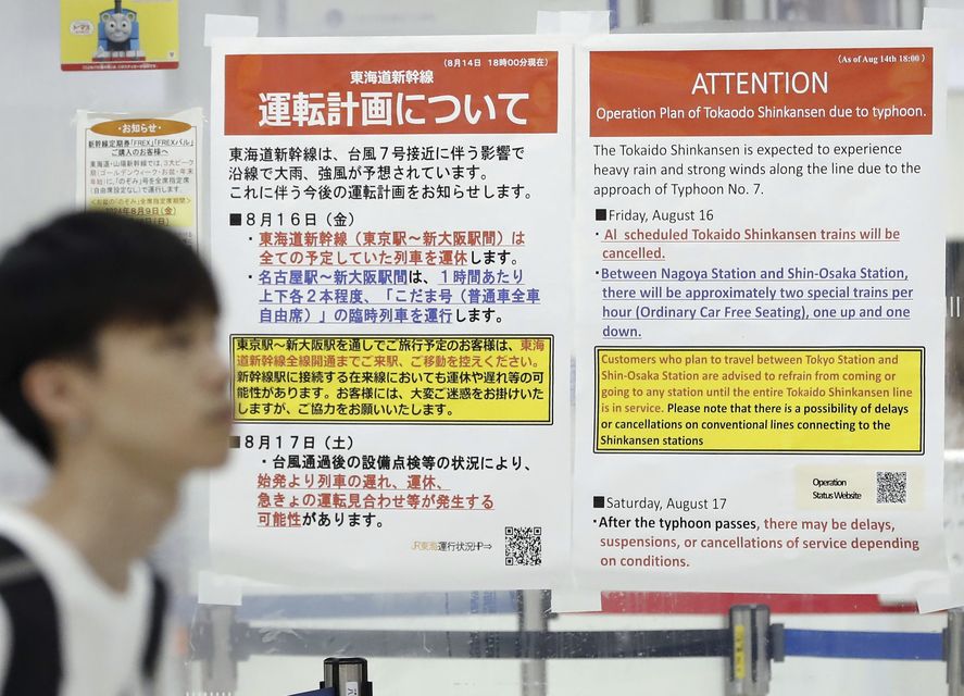 Station posters show the cancellation of Shinkansen bullet train services due to an approaching typhoon, at JR Tokyo station (Kyodo News via AP)