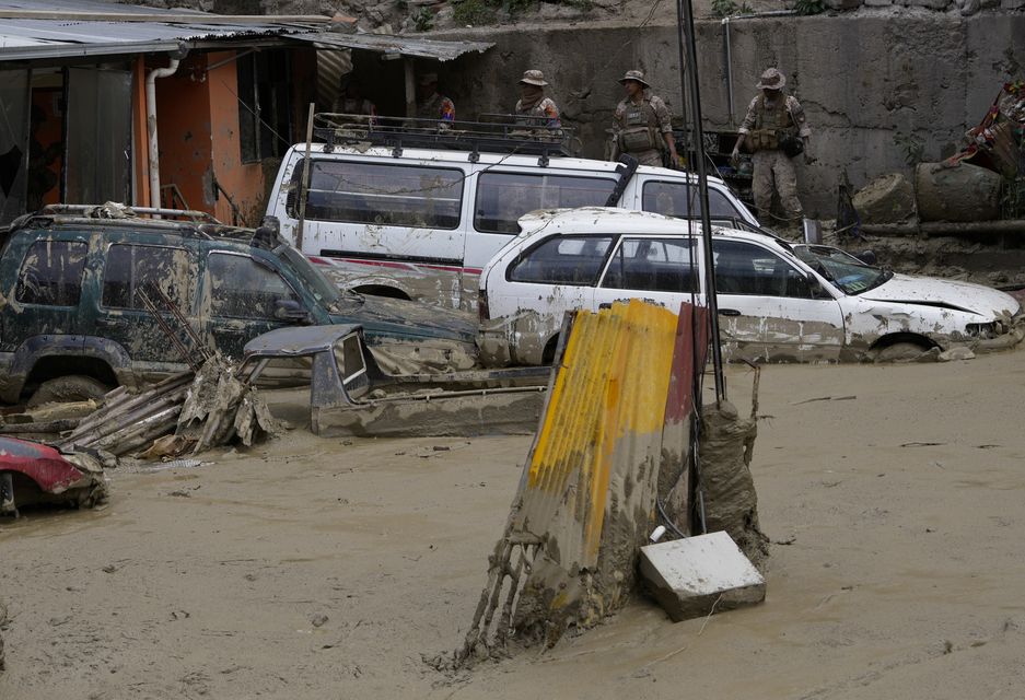 Cars are partially buried in mud in an area affected by a landslide triggered by heavy rains in La Paz (Juan Karita/AP)