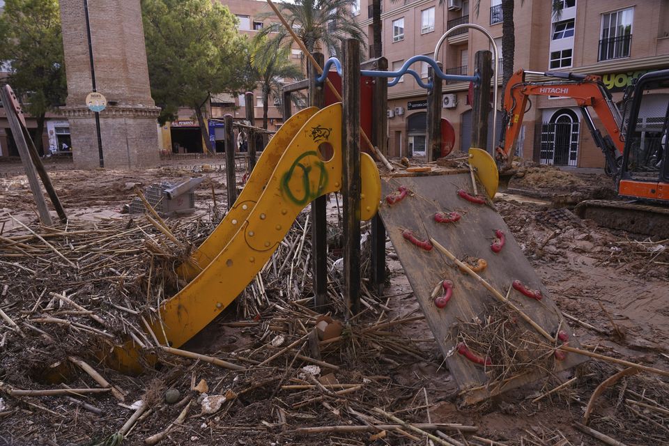 A children’s slide in a playground is covered with debris after floods in Catarroja (Alberto Saiz/AP)