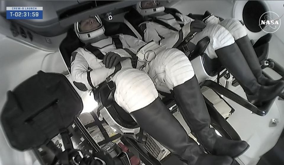 Nick Hague and Aleksandr Gorbunov inside the SpaceX capsule (NASA via AP/PA)