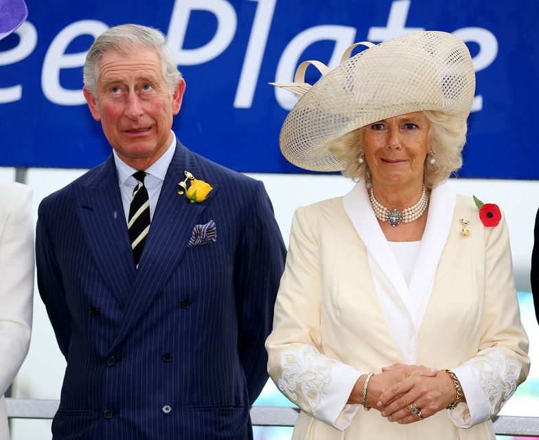 The Prince of Wales and the Duchess of Cornwall react to the sound of thunder as they attend the Melbourne Gold Cup Day at Flemington Race Course in 2012 (Chris Radburn/PA)