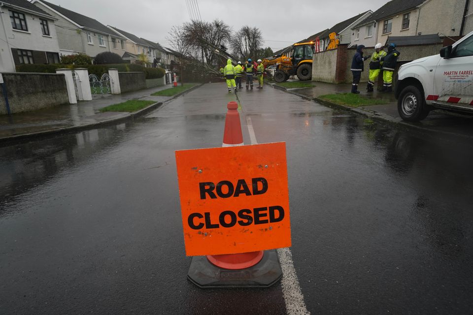 Workers clearing a fallen tree in Dublin as ESB networks continue to reconnect homes and businesses across the country after Storm Eowyn (Brian Lawless/PA)