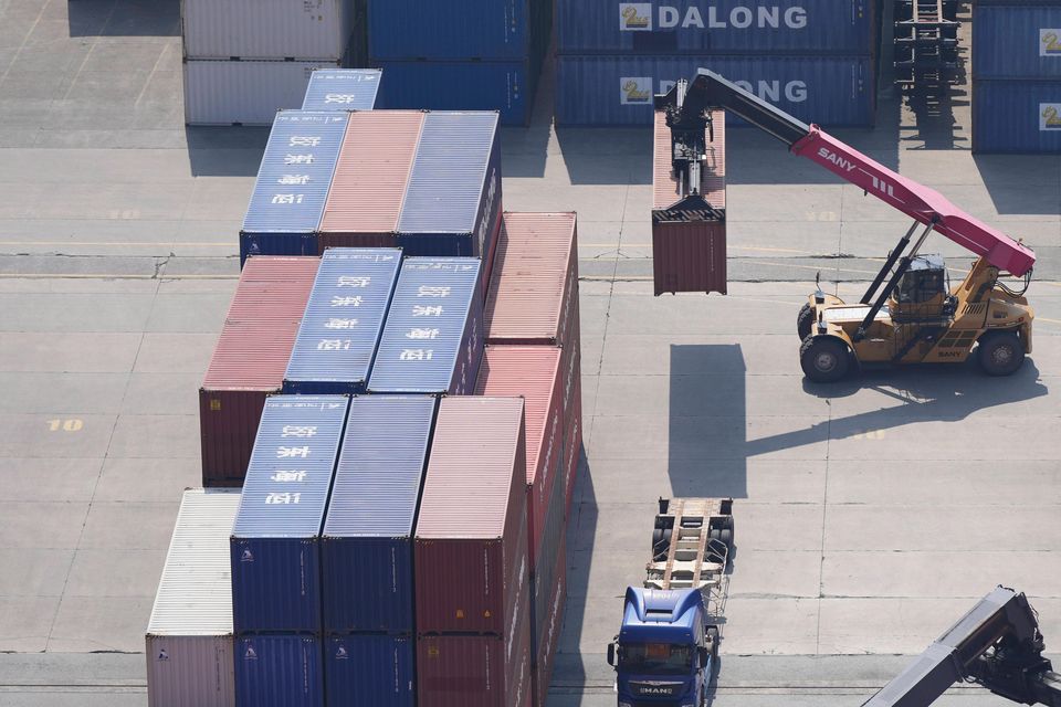 A crane, top, unloads a shipping container from a truck at a port in Pyeongtaek, South Korea (Lee Jin-man/AP)
