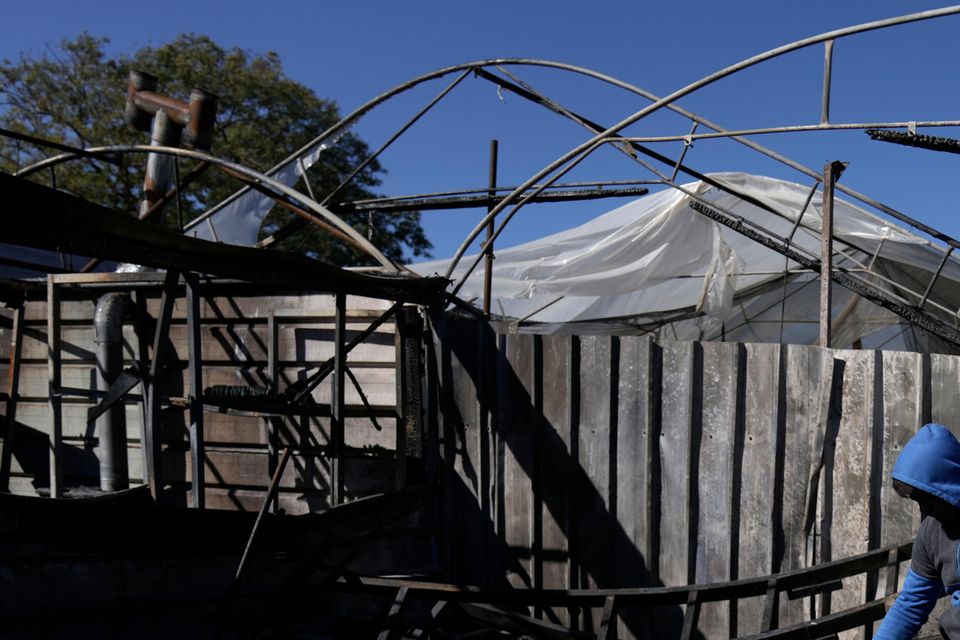 A Palestinian youth sifts through the aftermath of an attack by Israeli settlers in the West Bank village of Jinsafut (AP Photo/Majdi Mohammed)