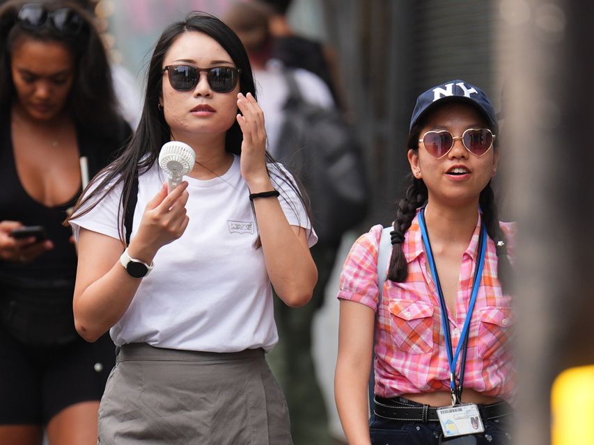 Hand fans are the hottest new accessory in these temperatures (James Manning/PA)