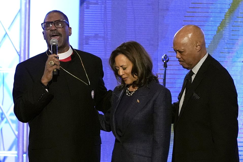 Bishops John Drew Sheard, left, and Michael Hill, right, lead the congregation in a prayer over Democratic presidential nominee Vice President Kamala Harris during a church service at Greater Emmanuel Institutional Church of God in Christ in Detroit (Jacquelyn Martin/AP)