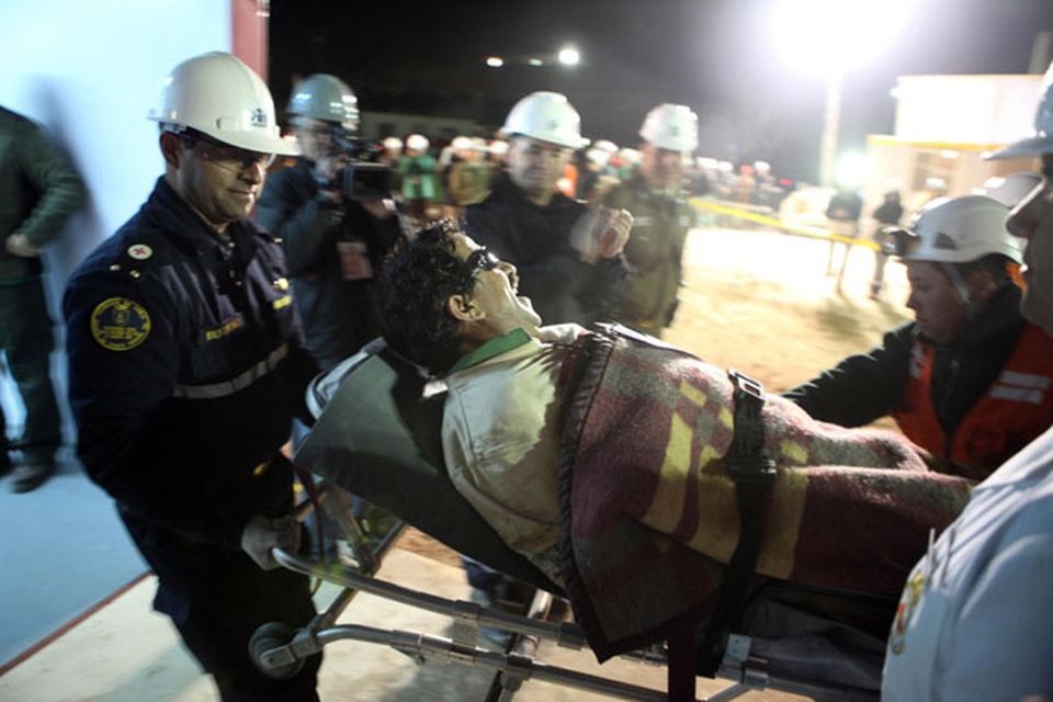In this photo released by the Chilean government, Bolivian miner Juan Illanes is carried away on a stretcher after being rescued from the collapsed San Jose gold and copper mine where he was trapped with 32 other miners for over two months near Copiapo, Chile, early Wednesday Oct. 13, 2010.  (AP Photo/Hugo Infante, Chilean government)