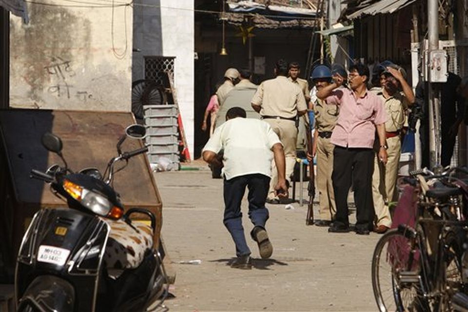 A local man ducks for cover as he crosses an alleyway exposed to fire from alleged gunmen holding a family hostage in Colaba, Mumbai, India, Thursday, Nov. 27, 2008. Teams of gunmen stormed luxury hotels, a popular restaurant, hospitals and a crowded train station in coordinated attacks across India's financial capital, killing at least 101 people, taking Westerners hostage and leaving parts of the city under siege Thursday, police said. A group of suspected Muslim militants claimed responsibility. (AP Photo/Saurabh Das)