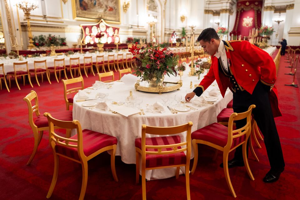 The finishing touches are applied by a senior footman to the tables in the Ballroom of Buckingham Palace (Aaron Chown/PA)