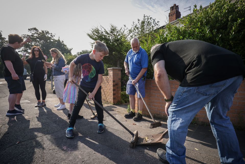 Sebastian Taylor, 10, helps to sweep Sussex Road in Southport after violent protests (James Speakman/PA)