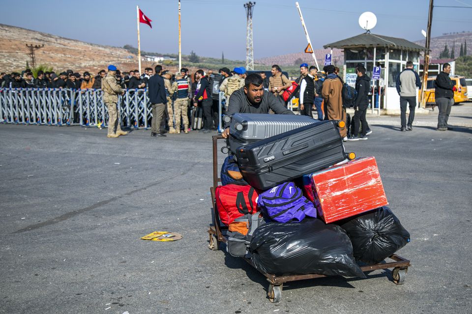 Syrians arrive to cross into Syria from Turkey at the Cilvegozu border gate, near the town of Antakya, southern Turkey (Metin Yoksu/AP)