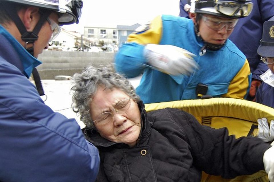 Sumi Abe, 80, is rescued from her destroyed home in Ishinomaki, Japan (AP)