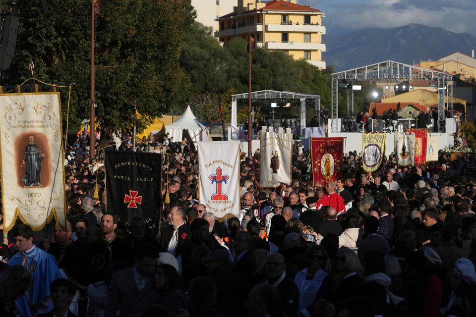 Members of catholic local brotherhoods arrive for Mass in Ajaccio (Thibault Camus/AP)