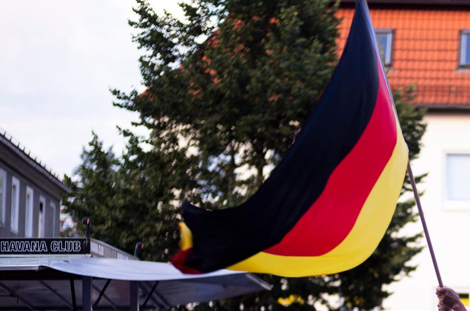 Supporters of the far-right Alternative for Germany party, or AfD, hold German national flags as they attend an election campaign rally (Markus Schreiber/AP)