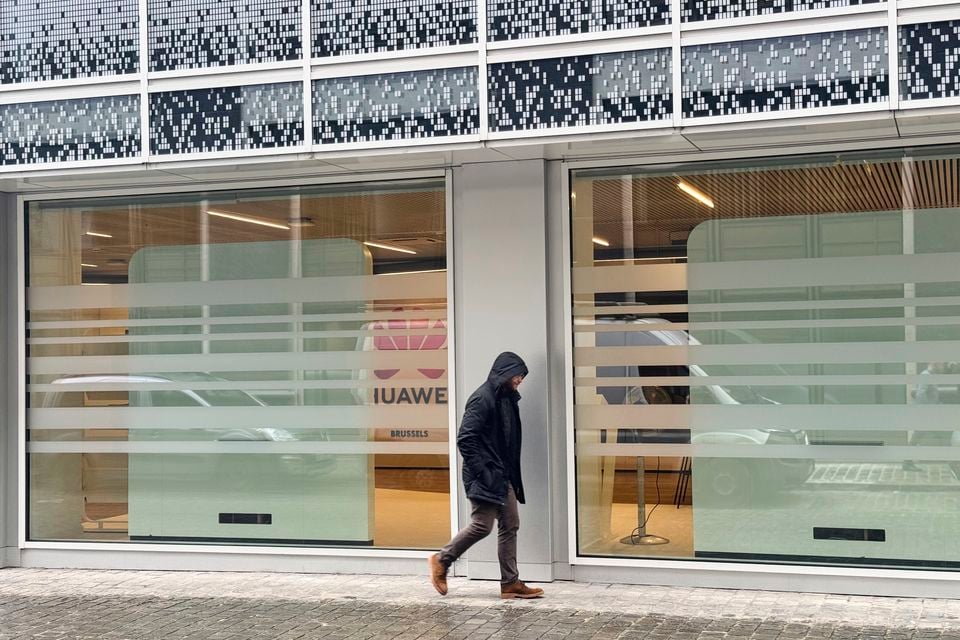 A man walks by the headquarters of Huawei in Brussels (Sylvain Plazy/AP)