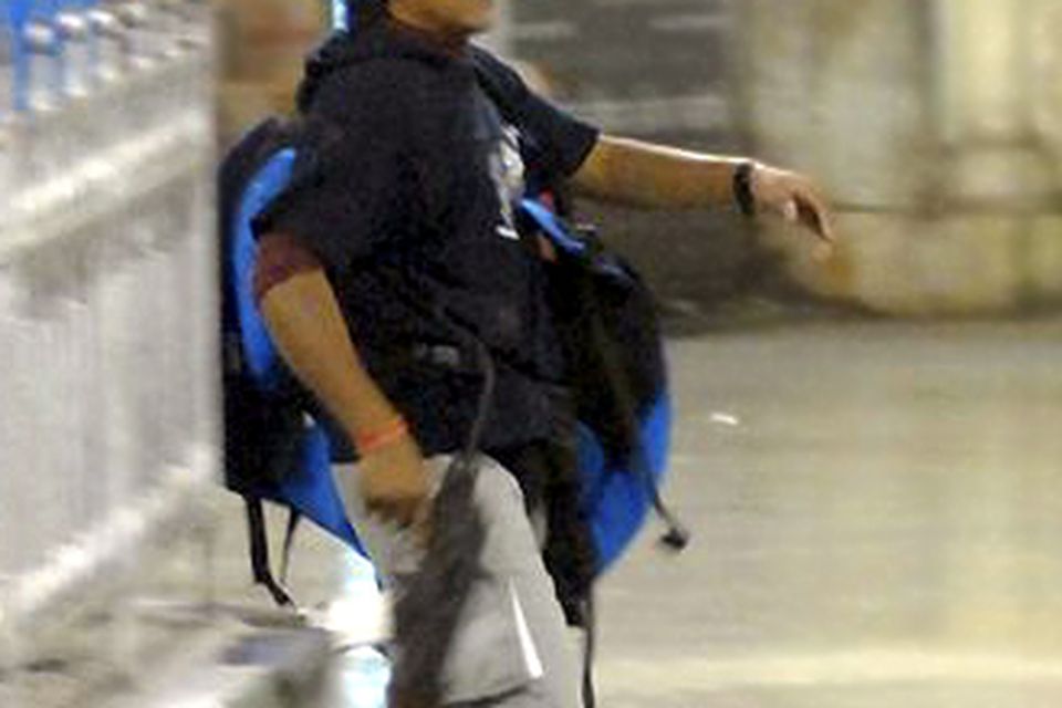 A gunman walks at the Chatrapathi Sivaji Terminal railway station in Mumbai, India, Wednesday, Nov. 26, 2008.