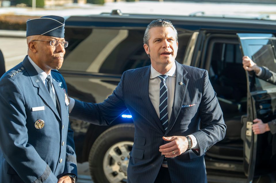 Defence secretary Pete Hegseth, right, pats Chairman of the Joint Chiefs of Staff General Charles Q. Brown Jr on his shoulder as he answers questions from reporters (AP/Kevin Wolf)