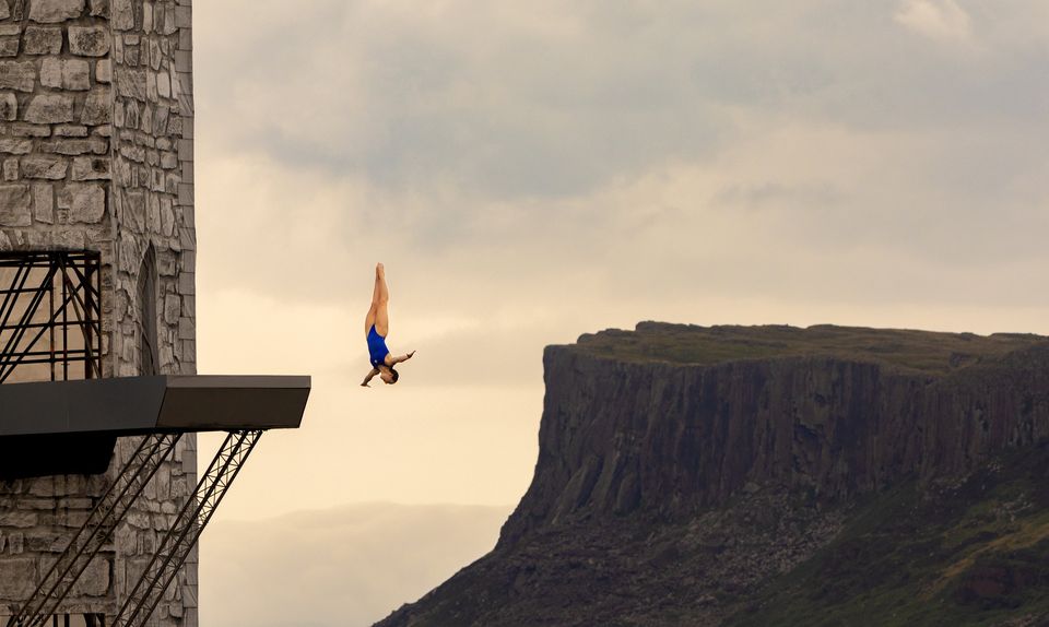 A diver heading for the water to the backdrop of Ballycastle's famous cliffs. Pic: Kevin Scott/Belfast Telegraph