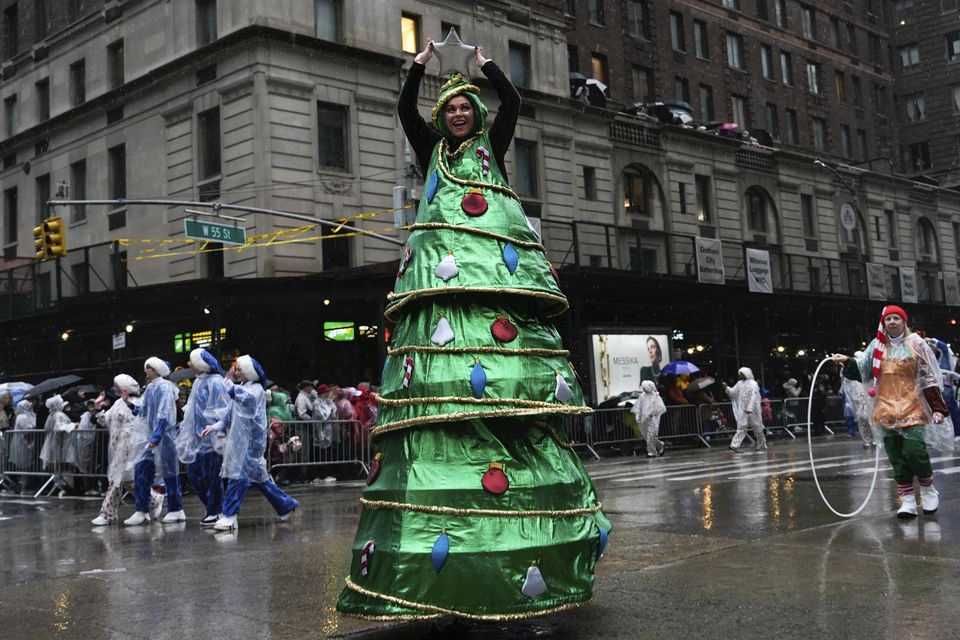 A performer dressed as a Christmas tree walks down Sixth Avenue (Julia Demaree Nikhinson/AP)