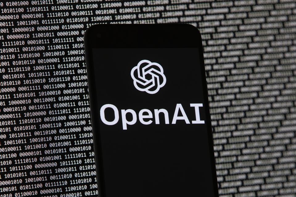 The OpenAI logo appears on a mobile phone in front of a computer screen (Michael Dwyer/AP)