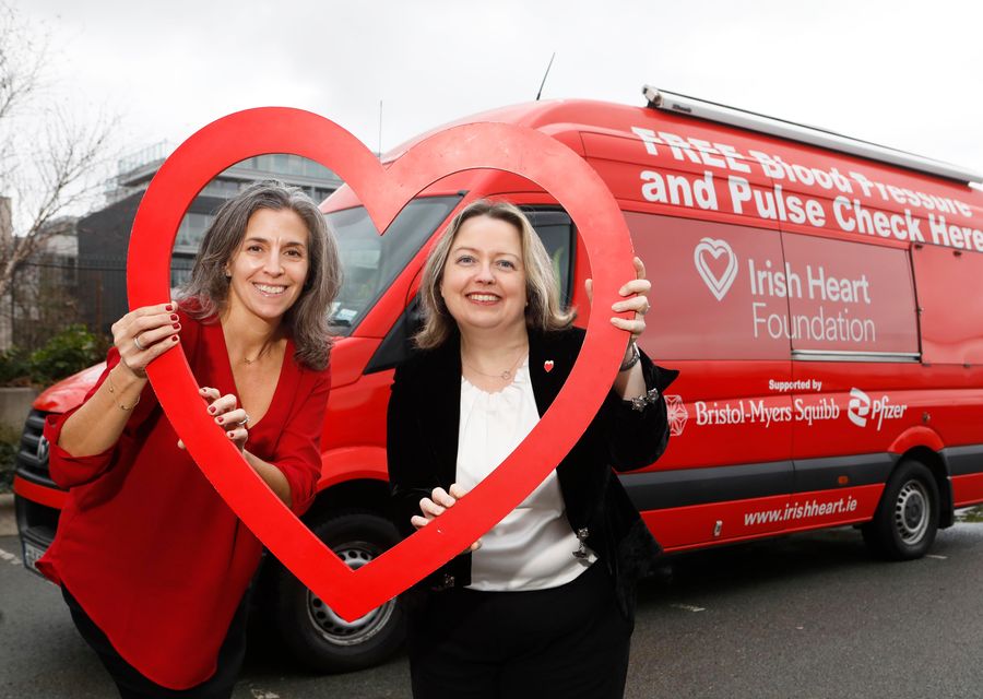 Deb Mangone, left, of Pfizer Healthcare Ireland and Janis Morrissey, from the Irish Heart Foundation, with the charity’s mobile health unit (Leon Farrell/Photocall Ireland/PA)