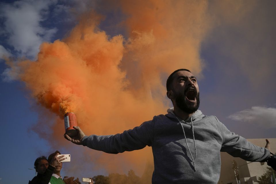 A man waves a flare during a celebratory demonstration in Damascus’ central square (Leo Correa/AP)