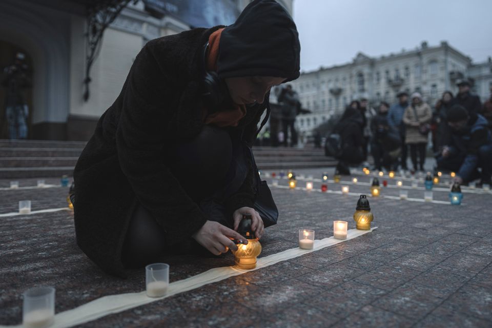 People light candles during a peaceful action to honour the memory of those killed in the Mariupol drama theatre a year ago, in Kyiv, Ukraine (Andrew Kravchenko/AP)