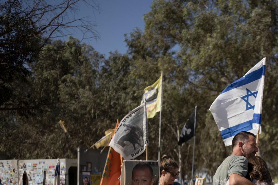 A family visits the the memorial marker of their loved one, Bar Lior Nakmuli, at the site of the Nova music festival, where hundreds of revellers were killed or kidnapped by Hamas (Maya Alleruzzo/AP)