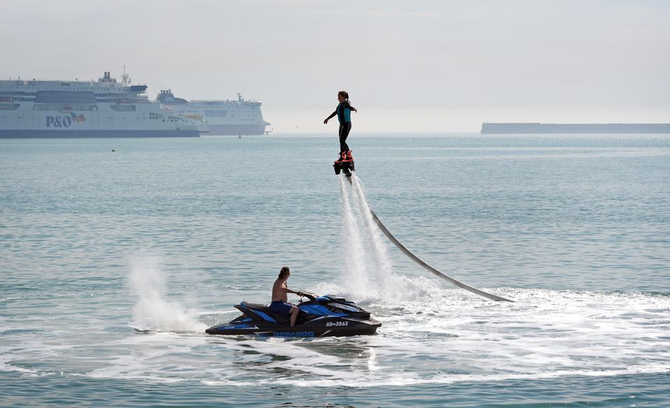 A lady enjoys flyboarding during the warm weather on the beach in Dover, Kent (Gareth Fuller/PA)