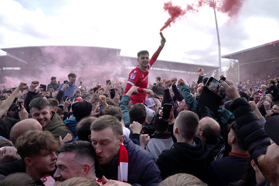 Wrexham fans celebrate back-to-back promotions on the pitch after the final whistle of their Sky Bet League Two match against Forest Green Rovers at the Racecourse Ground in April. The club is owned by Deadpool star Ryan Reynolds and It’s Always Sunny In Philadelphia creator Rob McElhenney (Jacob King/PA)