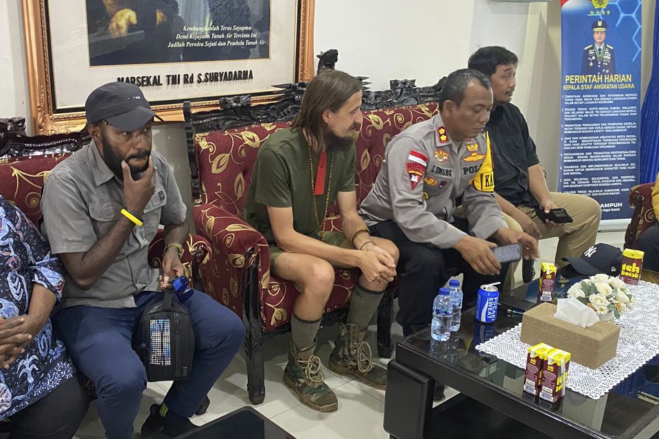 Mr Mehrtens, left, with police in Papua (Satgas Damai Cartenz via AP)