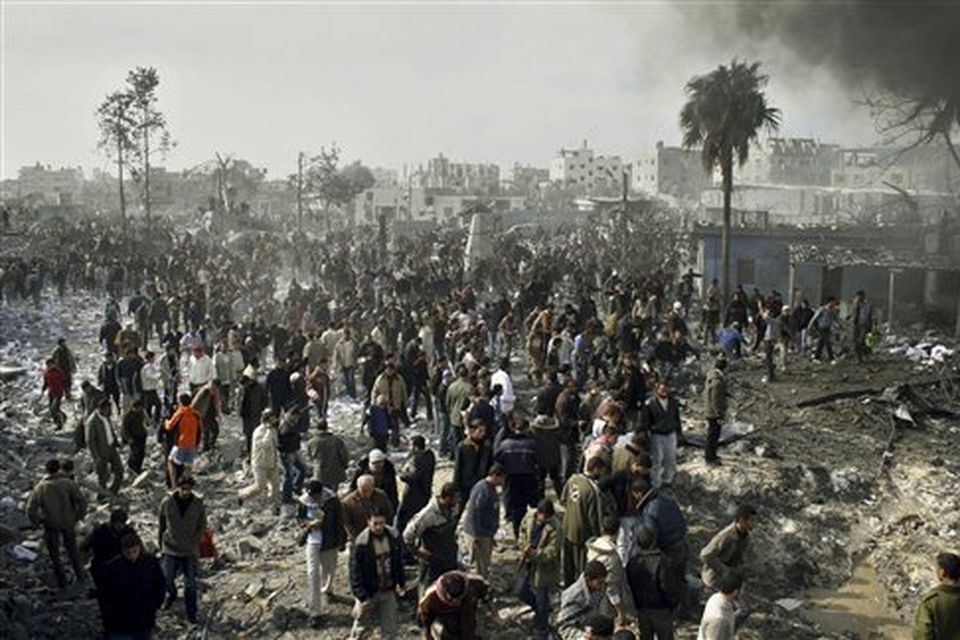 Palestinians gather at the site of a security compound used by the Islamic group Hamas following an Israeli missile strike in Rafah, southern Gaza Strip, Saturday, Dec. 27, 2008. Israeli warplanes demolished dozens of Hamas security compounds across Gaza on Saturday in unprecedented waves of simultaneous air strikes. Gaza medics said more than 120 people were killed and more than 250 wounded.(AP Photo/Hatem Omar)