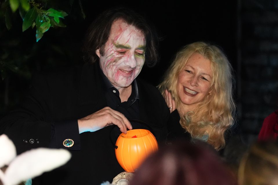 Jonathan Ross and his wife, Jane Goldman, outside their home handing out treats to trick-or-treaters (James Manning/PA)