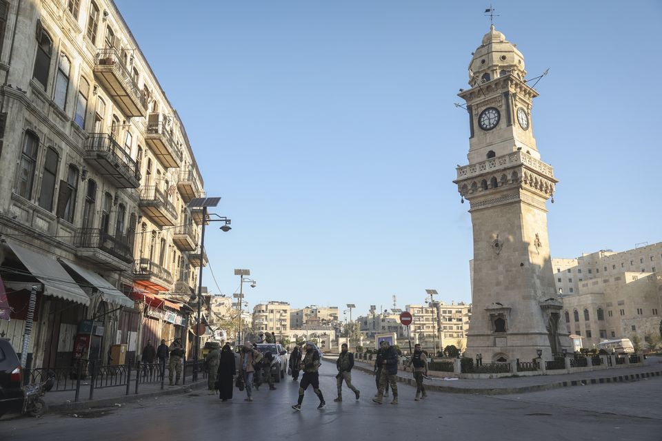 Syrian opposition fighters patrol the streets of Aleppo (Ghaith Alsayed/AP)