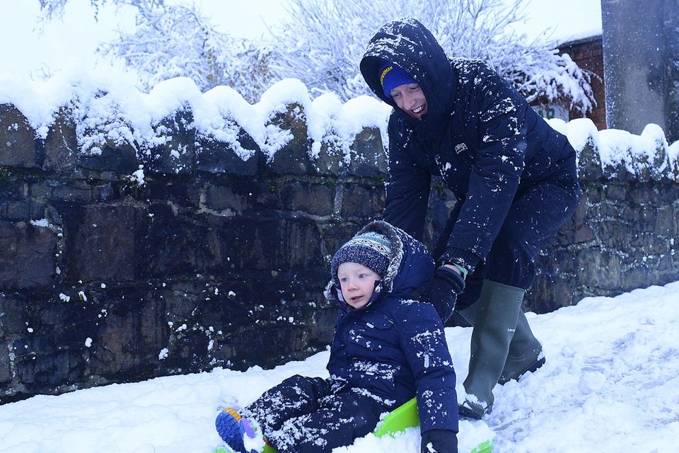 Pacemaker Press Belfast 08-12-2017: 
Heavy snow showers overnight have led to disruption across parts of Northern Ireland. Dozens of schools have been closed due to the wintery conditions. The snowfall means an unexpected day off for some young people. Police are advising road users to use extreme caution on the roads. Paul and Ollie Forbes pictured enjoying the snow.
Picture By: Arthur Allison/Pacemaker.