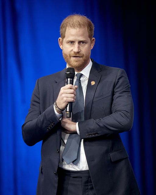 Harry reaches into his jacket pocket to pull out his mobile phone (Andres Kudacki/AP)