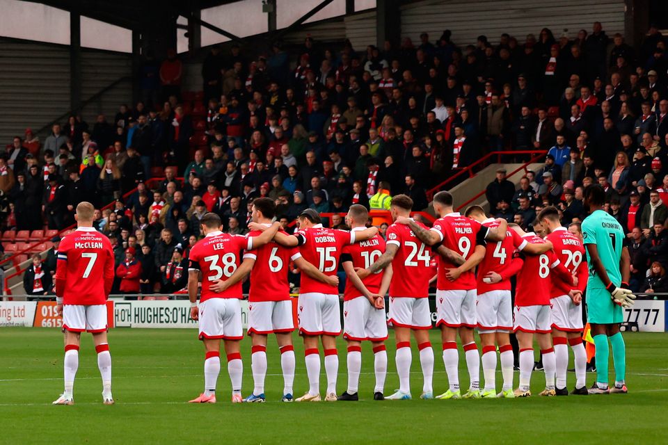 James McClean of Wrexham stood away from his team-mates during Saturday's minute silence before the game against Mansfield Town. Pic: Gary Oakley/PA Wire.