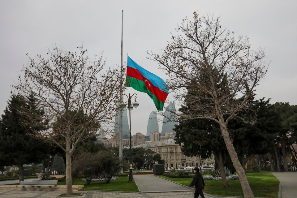 Azerbaijan’s national flag flies at half-mast in the centre of the capital, Baku, in memory of victims of the plane crash (Aziz Karimov/AP)