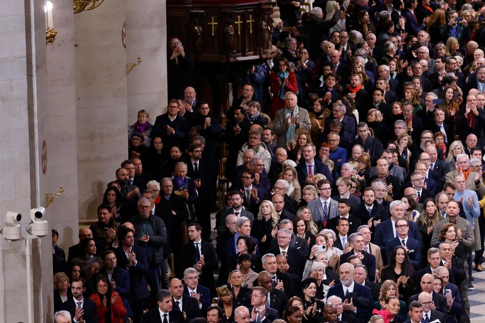 Firefighters, rescuers and builders involved in the restoration get applause in Notre Dame Cathedral (Ludovic Marin, Pool via AP)