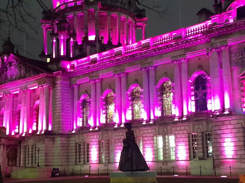 City Hall is lit up pink to support the Walkie Talkie Girlies group as they marched through Belfast on Wednesday night calling for action to protect women and girls on the streets of Belfast