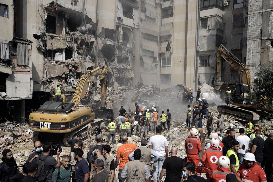 Emergency workers use excavators to clear the rubble at the site of Friday’s Israeli strike in Beirut’s southern suburbs (Bilal Hussein/AP)